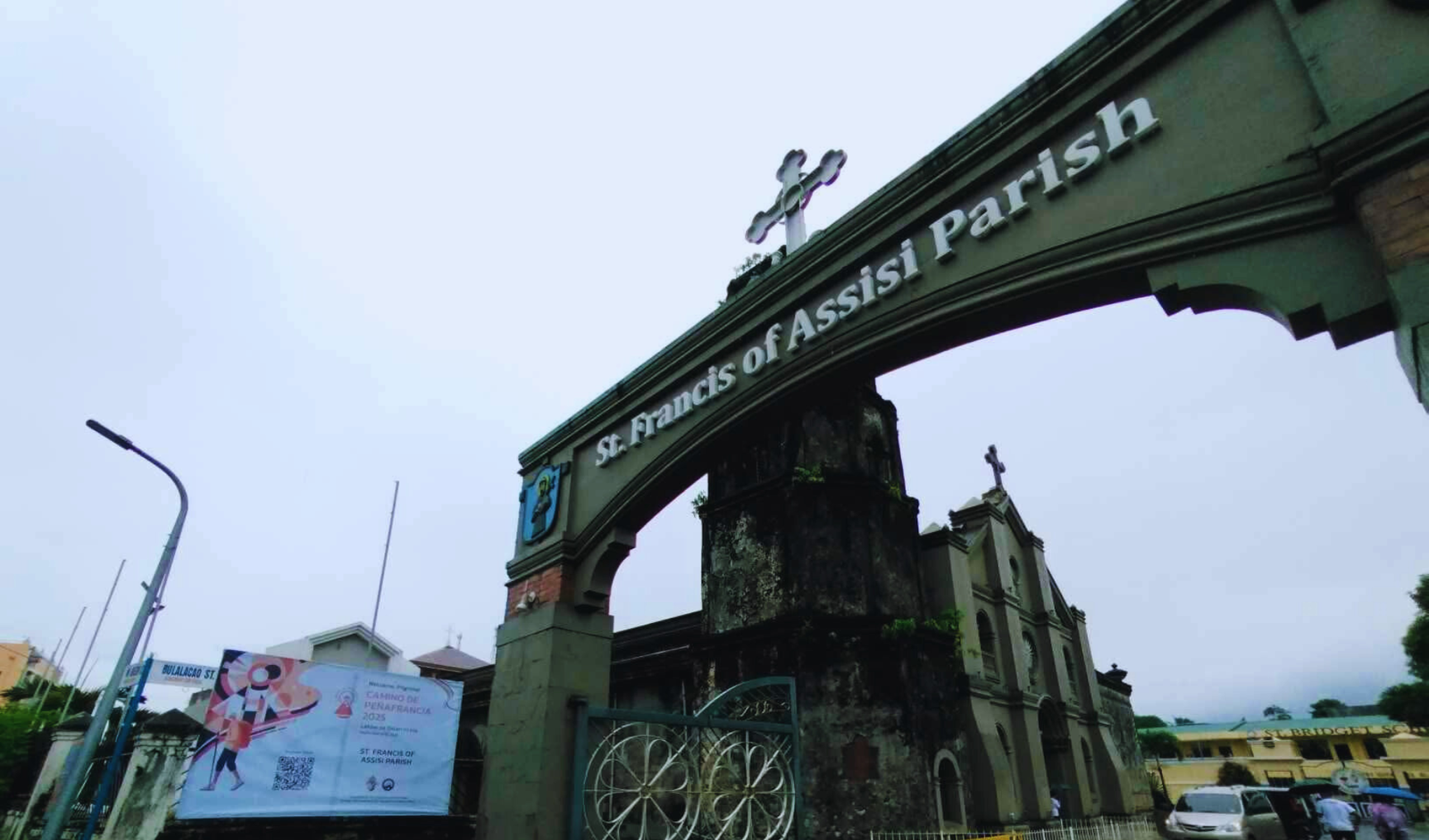 Entrance facade of St. Francis of Assisi Parish in Buhi, Camarines Sur, featuring its church doors and architectural details.